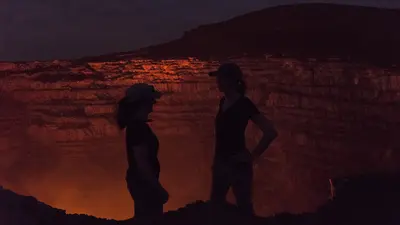 Lara and Diana Silhouetted against the glow of lava